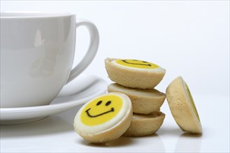 Pastry with smiley face and coffee cup, symbol