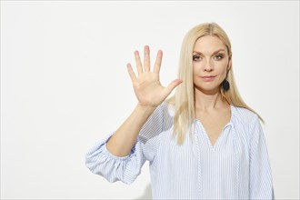 Attractive blonde woman shows five fingers. Counting with fingers