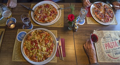 Restaurant table with various pizzas, Bavaria, Germanybd