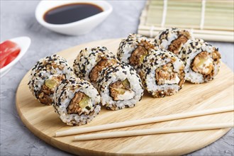 Japanese maki sushi rolls with salmon, sesame, cucumber chopsticks, soy sauce and marinated ginger