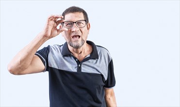 Amazed senior man taking off glasses isolated. Surprised senior man taking off glasses looking at