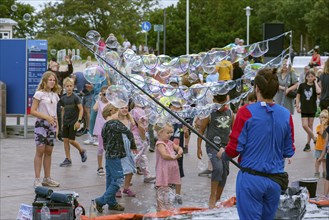 Man demonstrates soap bubbles to children on the promenade of Kühlungsborn, Mecklenburg-Vorpommern,