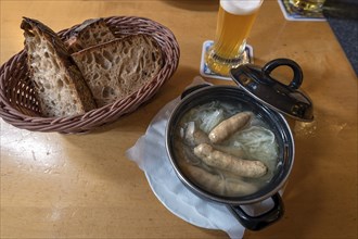 Saure Zipfel, boiled Nuremberg sausages, served with onion in a small pot in a pub, Nuremberg,