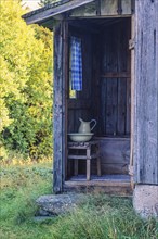 Idyllic old outhouse with a jug and sink in the country at summer, Sweden, Europe