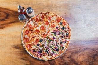 Top view of a supreme mixed pizza on wooden table. High angle view of mixed supreme pizza on wooden