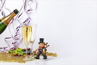 Two champagne glasses, pouring champagne, lucky charm for New Year, white background, copy space