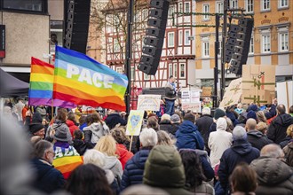 Speaker addresses a crowd with rainbow flags at a demonstration, demonstration against the right,