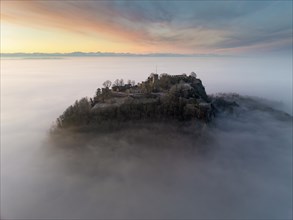 Aerial view of the Hegau volcano Hohentwiel with the upper fortress ruins in front of sunrise,