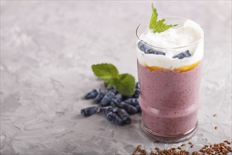 Smoothie with honeysuckle, linen and chia in a glass on gray concrete background. side view, close