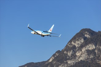 TUI airline aircraft taking off at Innsbruck Kranebitten Airport, Boeing 737-800. Snow-covered