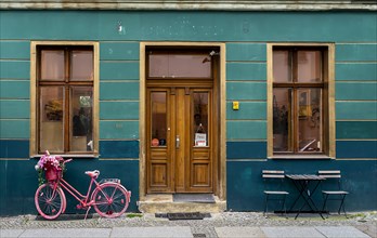 Pink bicycle in front of a house entrance in Berlin-Prenzlauer Berg, Germany, Europe