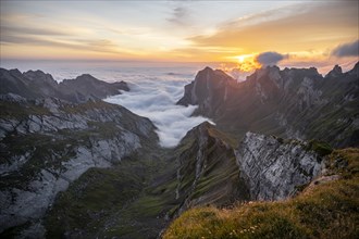 View over SÃ¤ntis mountains into the valley of Meglisalp at sunrise, high fog in the valley,