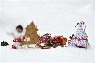 Christmas decoration, Inuit pulling sleigh with Christmas presents through the snow