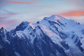 Red-coloured clouds over the summit of Mont Blanc with Aiguille du Midi in the foreground, Savoie,