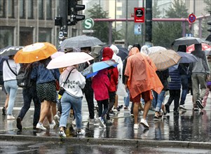 Tourists with rain capes and umbrellas during heavy rainfall, Berlin, 23 06 2023