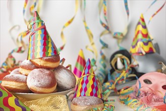 Colourful carnival table with doughnuts, pink mask and decoration