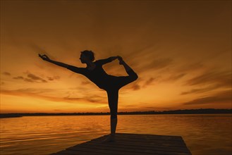 Woman practicing yoga posture Natarajasana, Lord of the Dance Pose, one legged standing, balancing,