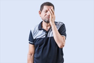 Tired and exhausted old man covering his face with the palm of his hand. Exhausted senior man