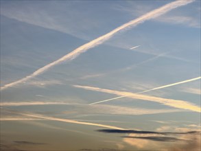 Several many tens of condensation trails high thin clouds artificially created by aircraft engines