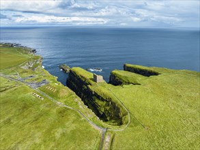 Aerial view of the ruined Castle of Old Wick surrounded by rugged cliffs on the North Sea coast,