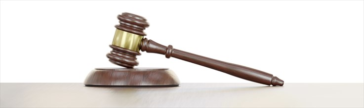 Gavel resting on a wooden table against a white background