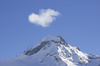 White cloud over snow covered mountain top, pinnacle Ciarforon in winter in the Gran Paradiso