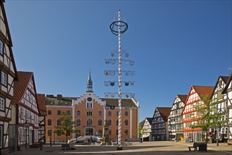 Market square with maypole and town hall in the historic old town with many half-timbered houses,