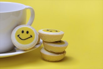 Pastry with smiley face and coffee cup, symbol