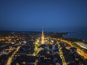 Aerial view of the city of Radolfzell at night with the illuminated Radolfzell Minster, Radolfzell