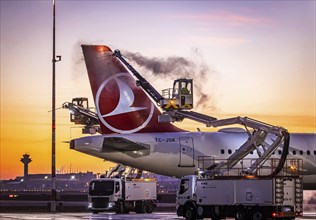 Frost at the airport, a Turkish Airlines aircraft is de-iced in front of sunrise. Airbus A321-231,