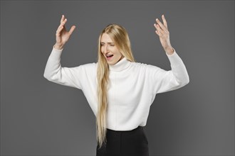 Dissatisfied young woman swears and gesticulates emotionally with her hands