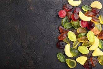 Various fruit jelly candies on black concrete background. top view, flat lay, copy space