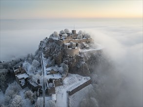 Aerial view of the Hegau volcano Hohentwiel with Germany's largest fortress ruins on a cold, foggy