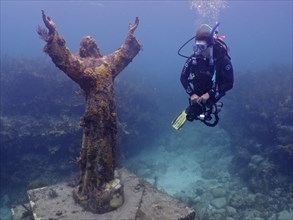 Diver looking at the statue of Jesus Christ underwater (Christ of the Abyss), dive site John