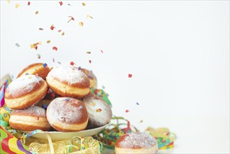 Colourful streamers, flying confetti and doughnuts, carnival, copy room, white background