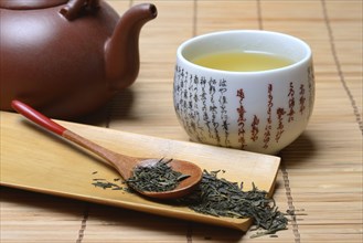 Green Sencha tea in tea bowl and tea leaves in wooden spoon, green tea, Japan, Asia