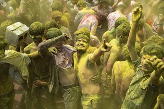 Revellers dancing in the beat of music as they celebrate Holi on a street, the Hindu spring