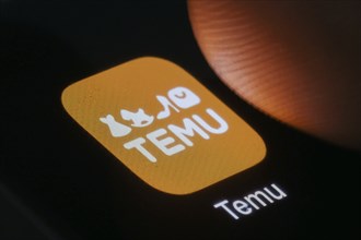 The logo of the Temu app (online marketplace) from Chinese company PDD Holdings can be seen next to