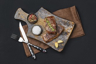 Top view of pan seared beef steak on dark background