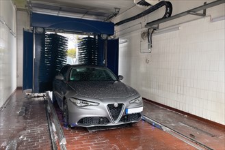 Front view of motor vehicle sporty sedan Italian make automobile Alfa Romeo Giulia being sprayed in