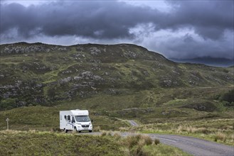 Motorhome, campervan driving along winding single track road with passing places in the Scottish