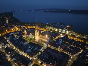 Aerial view of the city of Radolfzell at night with the illuminated Radolfzell Minster, Radolfzell