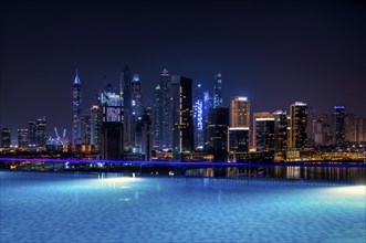 Night shot rooftop pool, swimming pool, Dubai Marina skyline behind, Hotel NH Collection The Palm