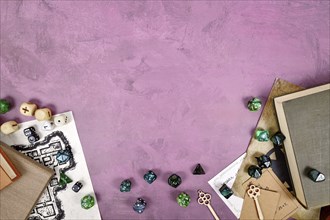 Tabletop role playing flat lay with colorful RPG dices, rule books, dungeon map on purple