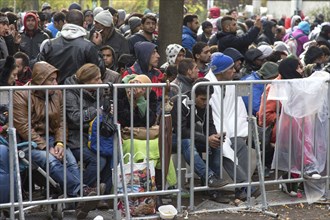 Refugees from Syria wait behind barriers in the Central Reception Centre for Asylum Seekers at the