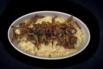 Cheese spaetzle with fried onions on a dark background, Bavaria, Germany, Europe