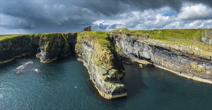 Aerial panorama of the ruined Castle of Old Wick surrounded by rugged cliffs on the North Sea