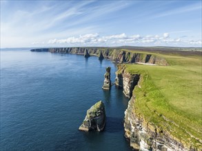 Aerial view of the rugged coastal landscape at Duncansby Head with rock tower, behind it the