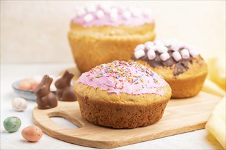 Homemade glazed and decorated easter pies with chocolate eggs and rabbits on a white concrete