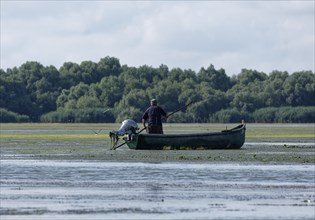 Fishermen in a boat on the water of Lacul Isaccel, a lake in the Danube Delta. UNESCO Danube Delta